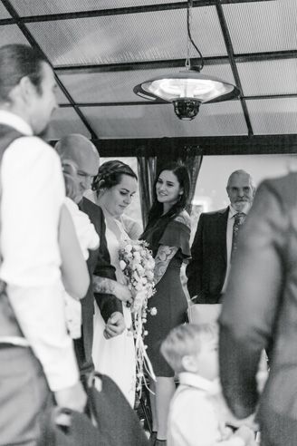 Black and white candid wedding reception photo showing guests and decor.