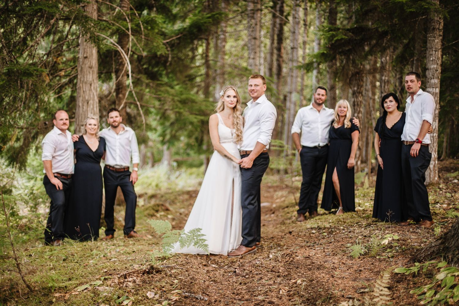 Wedding group photos taken in natural woodland setting with guests.