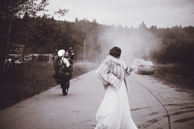 A dramatic black and white wedding photo on a misty road with smoke effects.