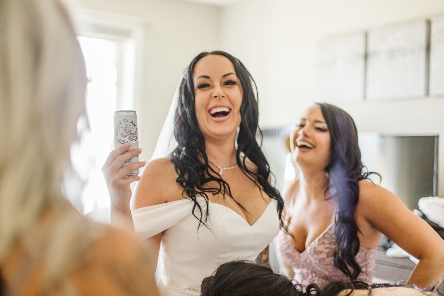 Wedding preparation scene with joyful laughter and celebration indoors.