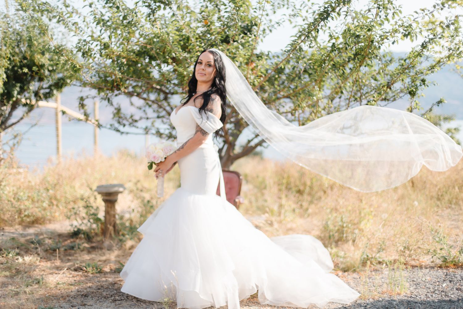 Flowing white wedding dress captured in motion against natural outdoor backdrop.