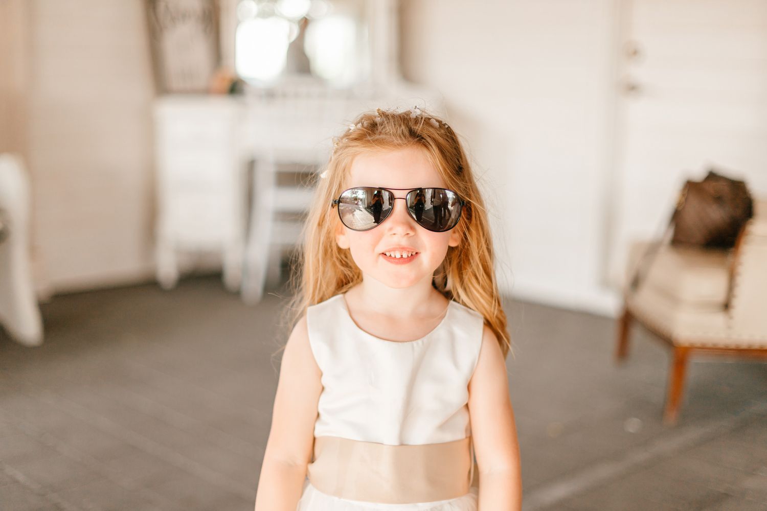 Children in formal attire playing and smiling during wedding preparations.