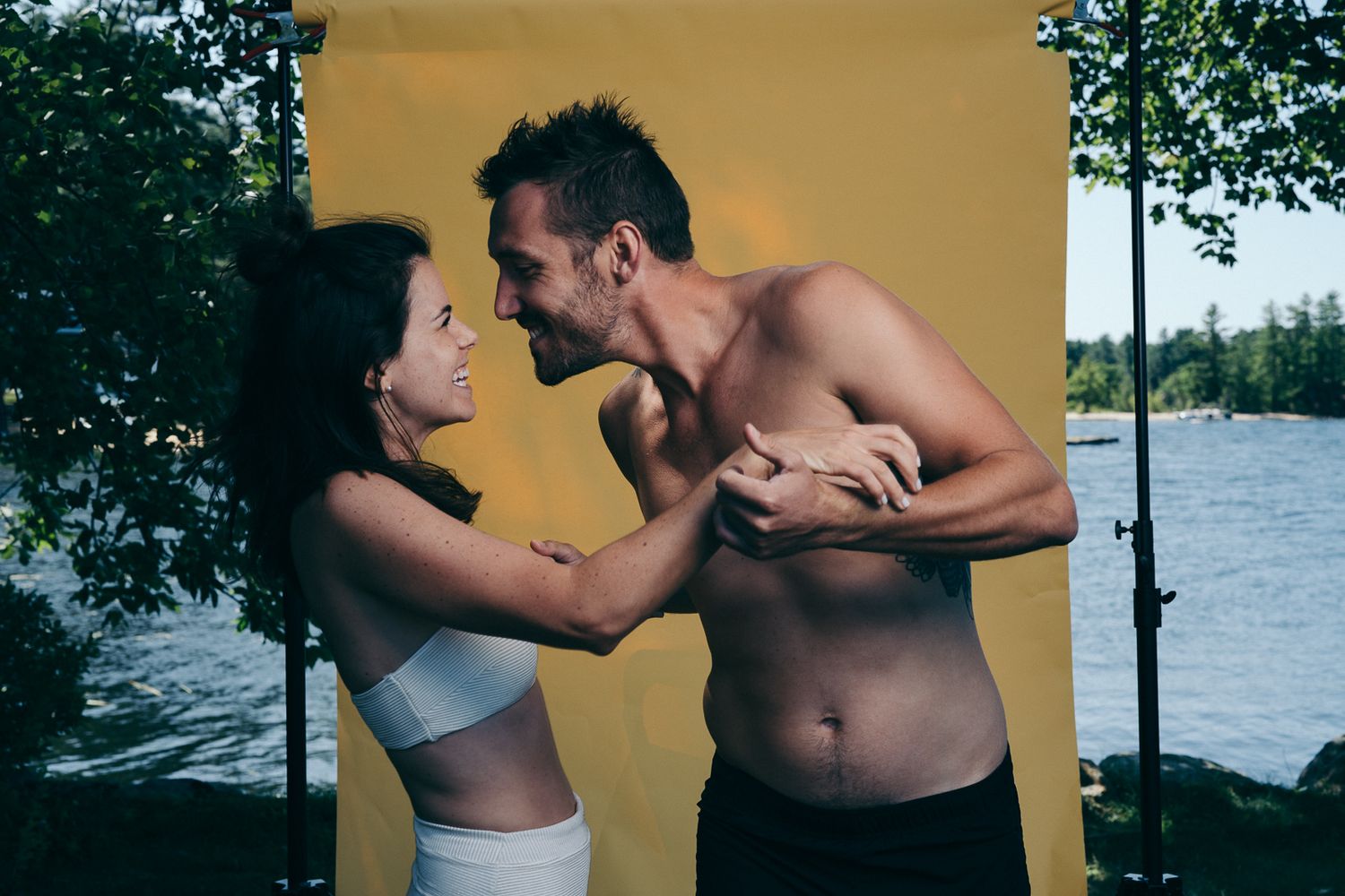 Couple in athletic wear sharing a playful moment by the water.