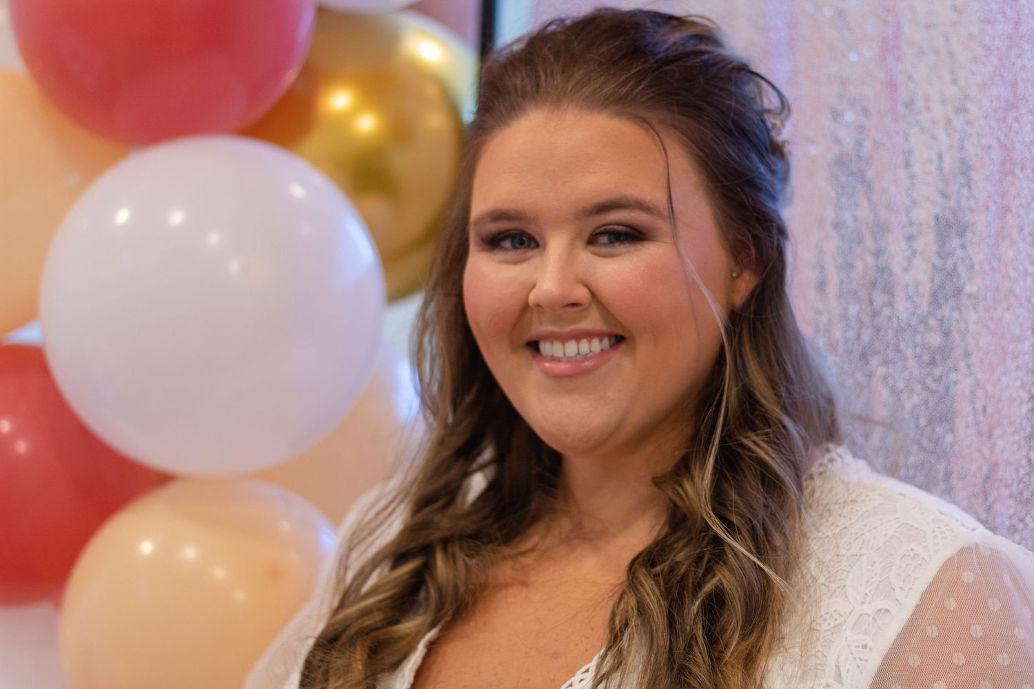 soon-to-be bride in front of balloon arch at wedding shower