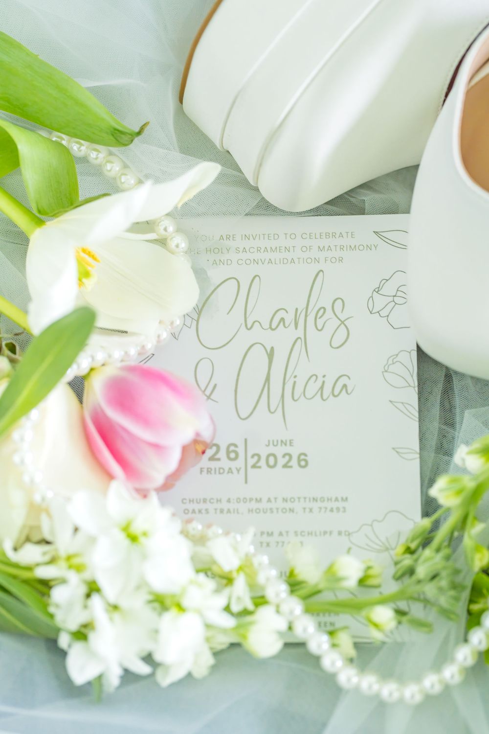 Elegant wedding invitation for Charles and Alicia, June 2026, surrounded by white flowers, pearl necklace, and bridal heels.