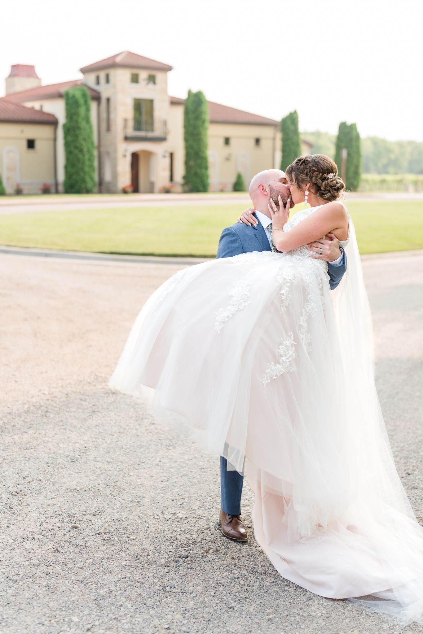 Romantic couple embracing outside a Mediterranean-style wedding venue.