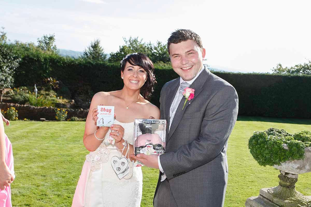 Bride and groom smiling and posing for a fun photo outside Roundthorn Country House wedding venue - Penrith