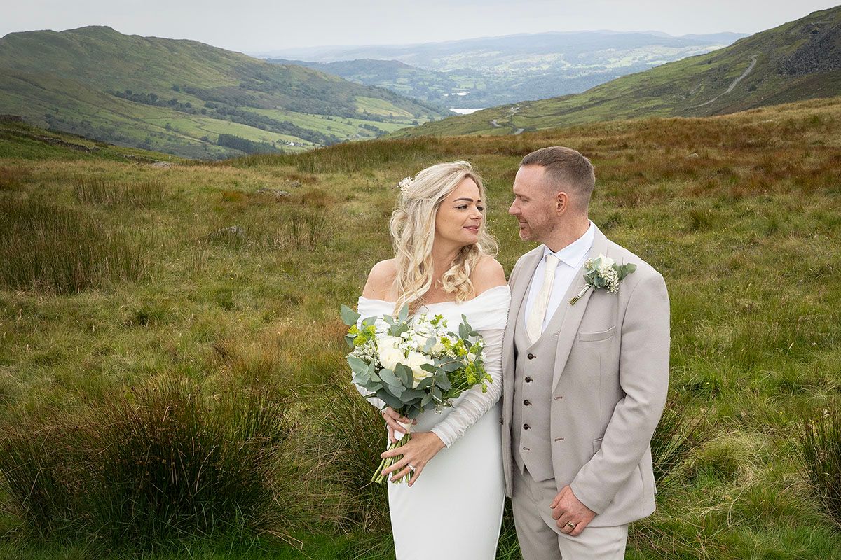 Bride and groom pose in scenic Lake District scene during their elopement wedding