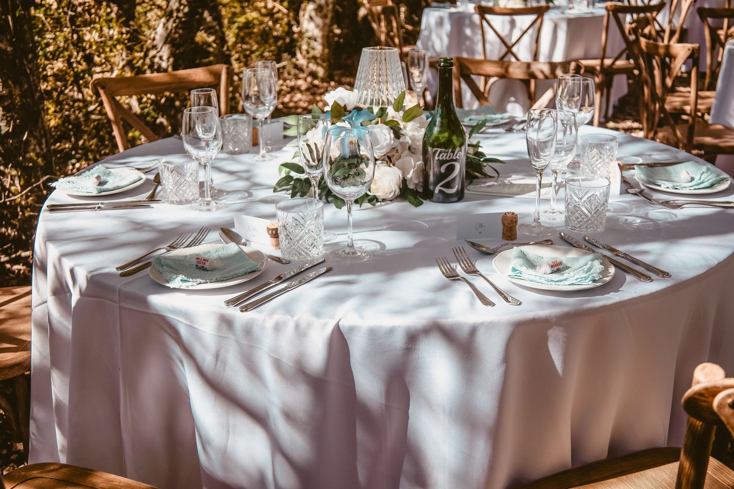 Wedding reception table set beneath the trees at Château Sainte-Croix.