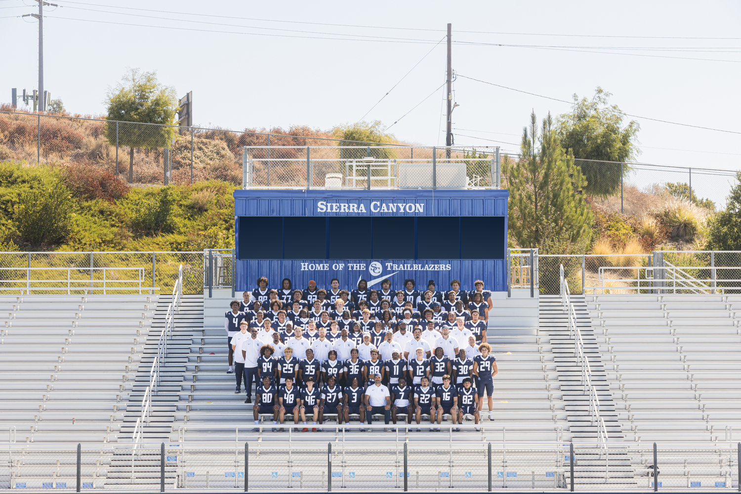 Sierra Canyon Trailblazers football team poses for a group photo on the bleachers of their home stadium.