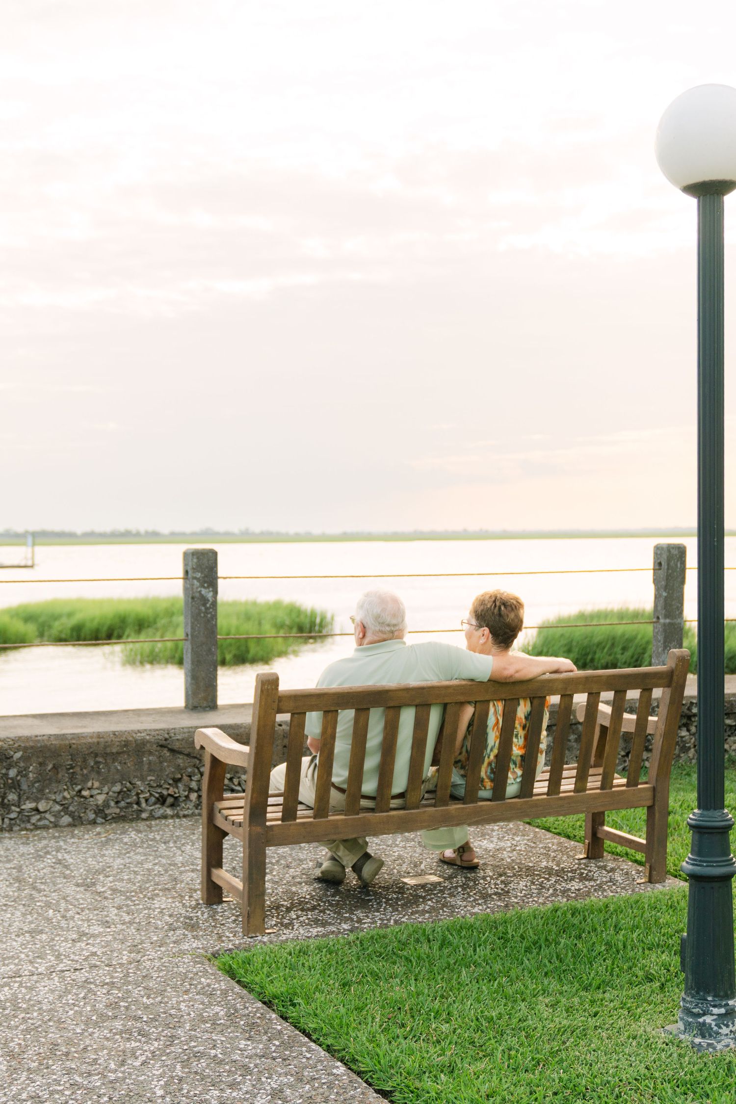 Lori and Kenny sit together overlooking the water during their Jekyll Island anniversary portrait session with Lindy Rebro Photography
