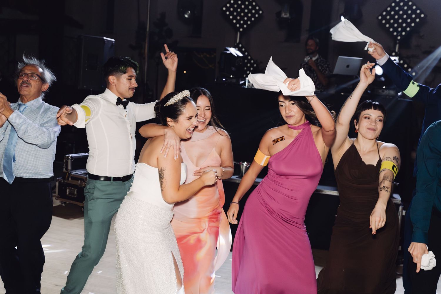 Bride dances joyfully with wedding guests on the dance floor during the wedding reception celebration.