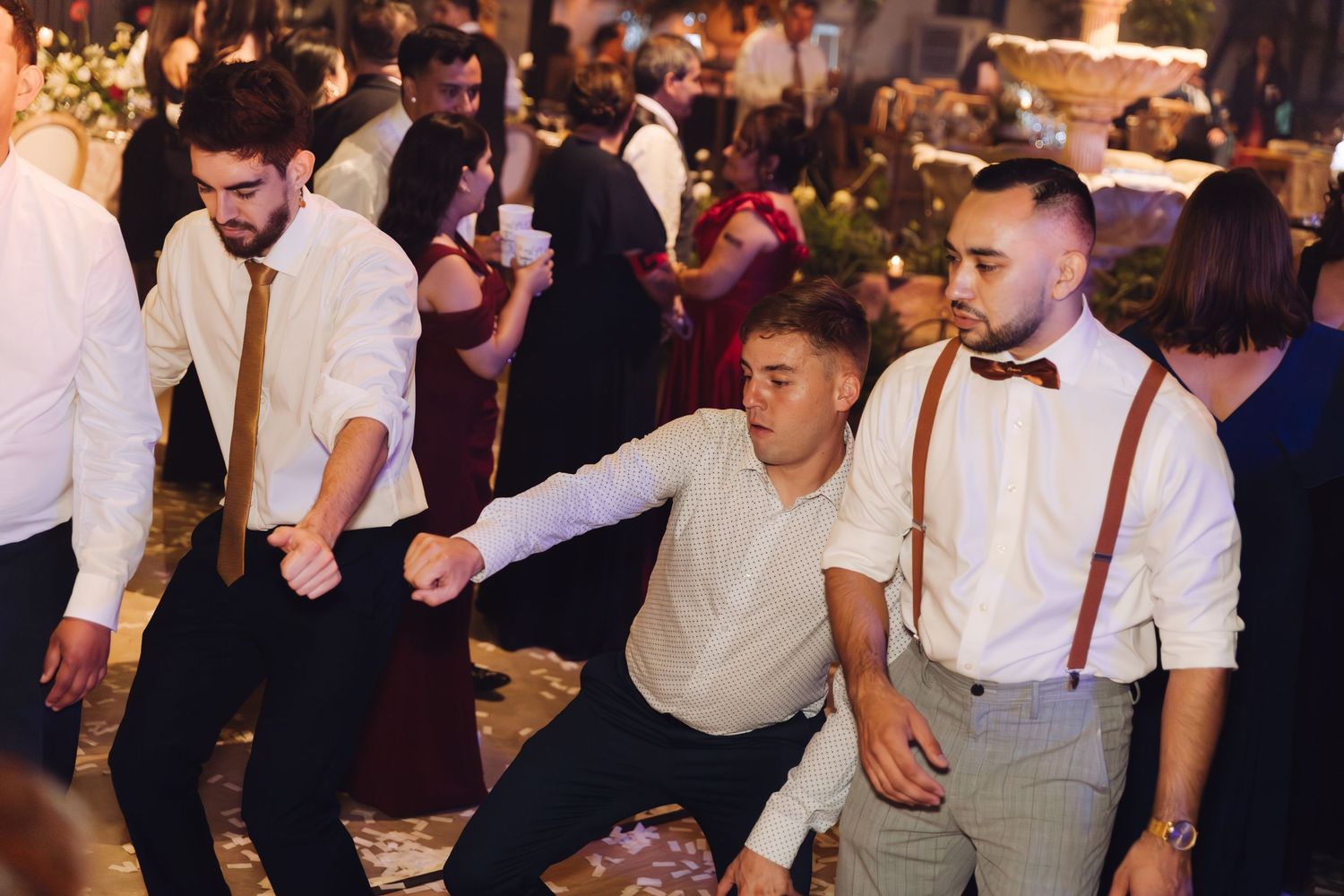 Young men dancing and having fun together at a wedding reception celebration.