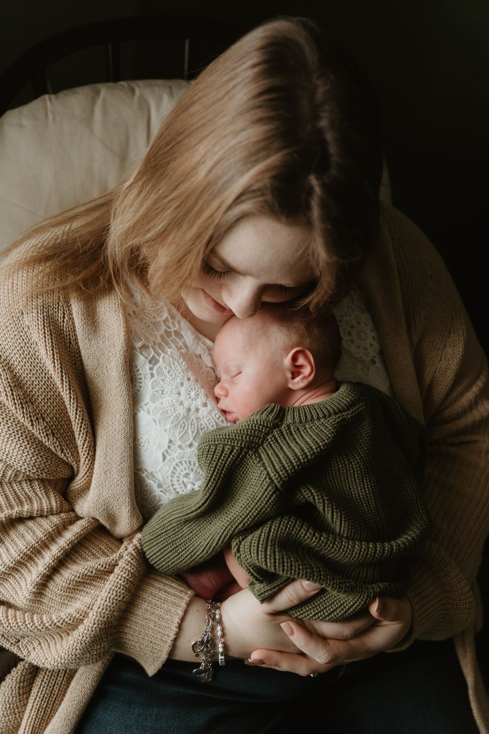 Natural window light mother holding newborn close during newborn in-home portrait session Tyler Tx Motherhood photographer