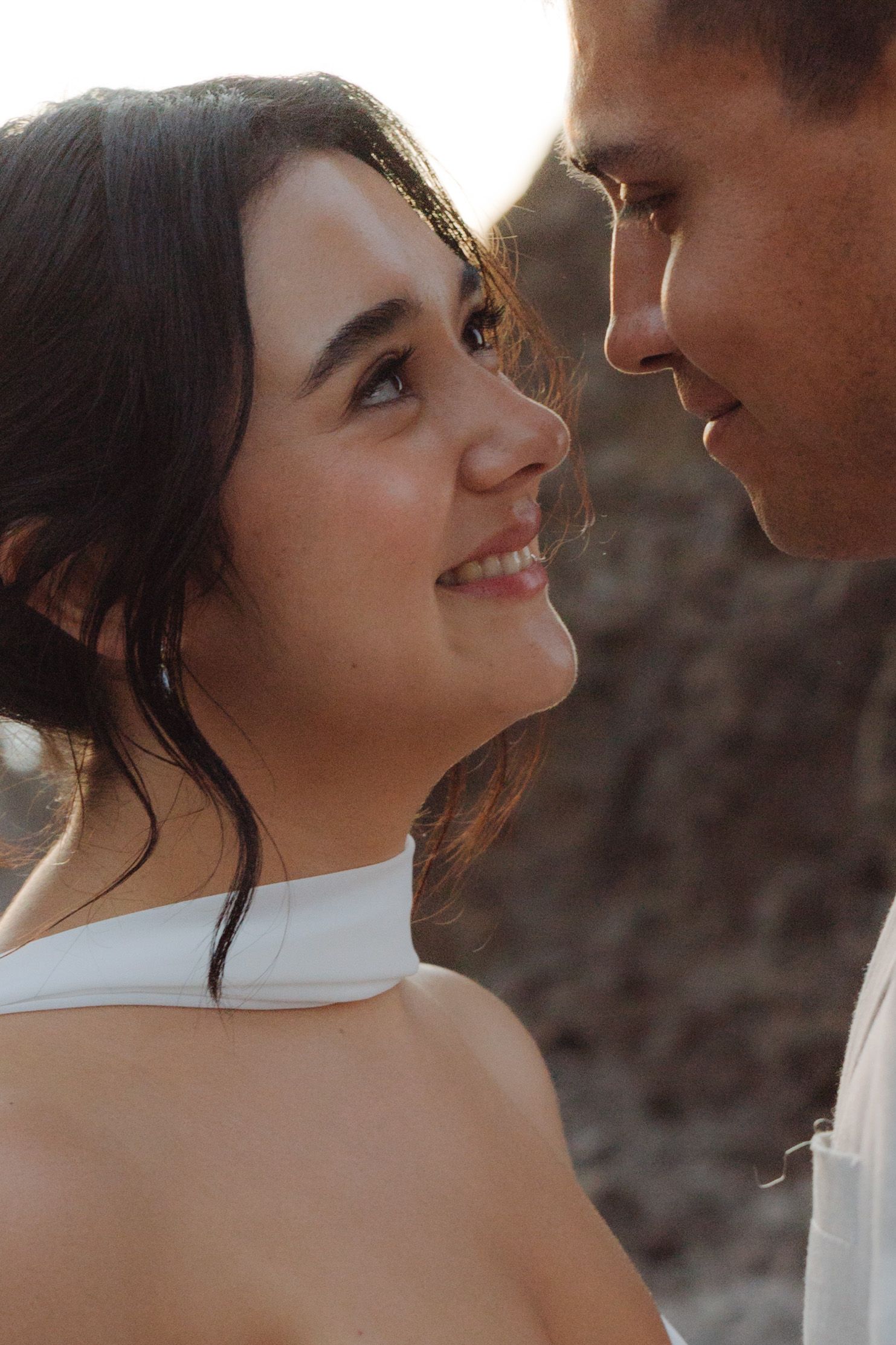 Close-up portrait of a smiling bride looking up at her groom during an intimate outdoor wedding photo session.