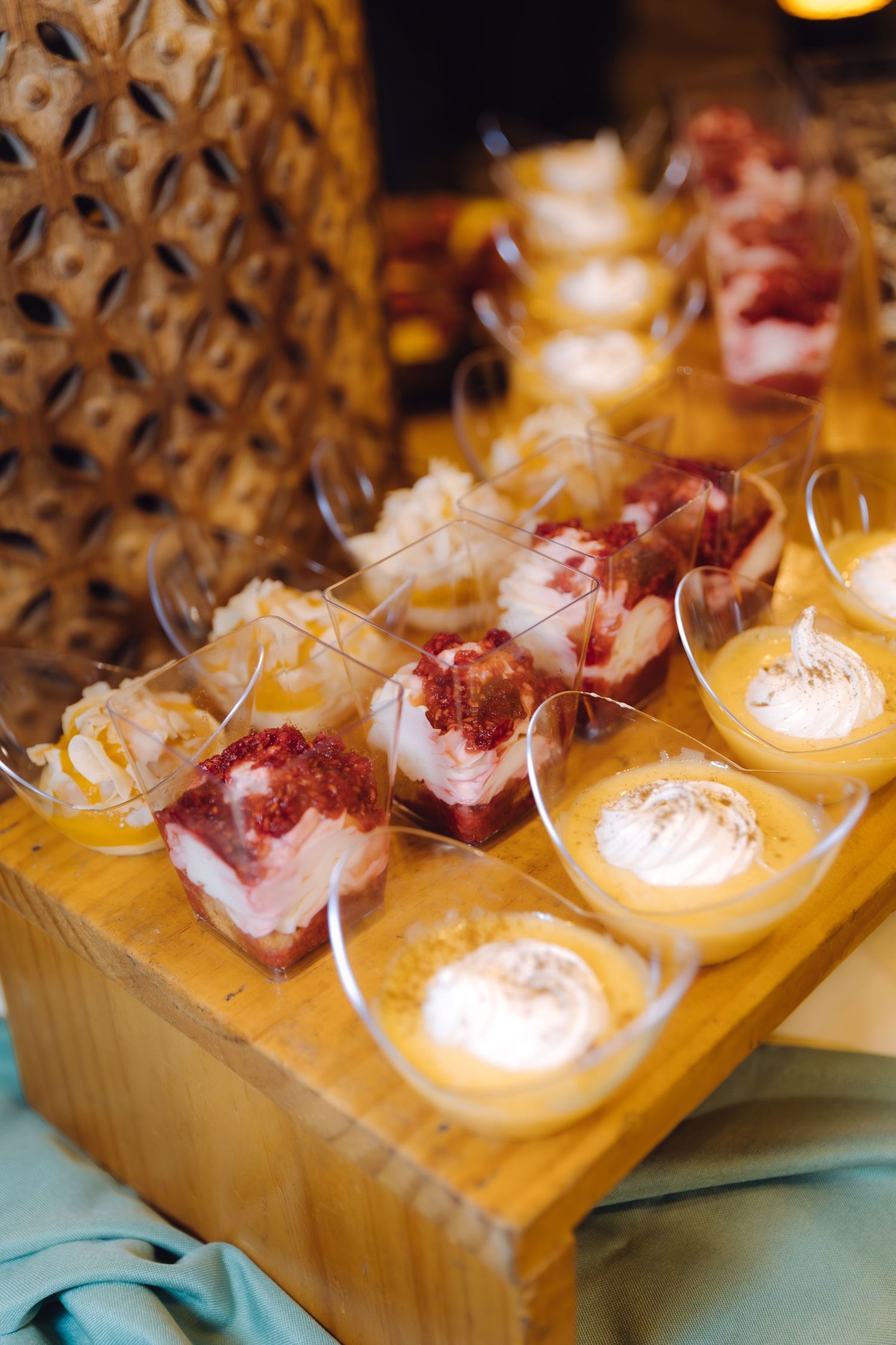 Elegant dessert display with strawberry and cream individual cups on wooden stand.