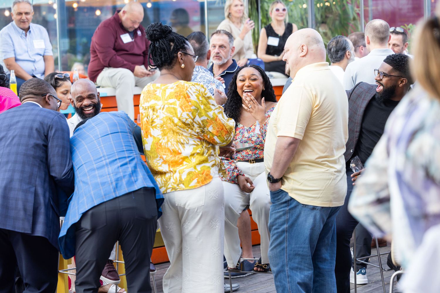 Diverse group of professionals socializing and networking at an outdoor corporate evening reception.