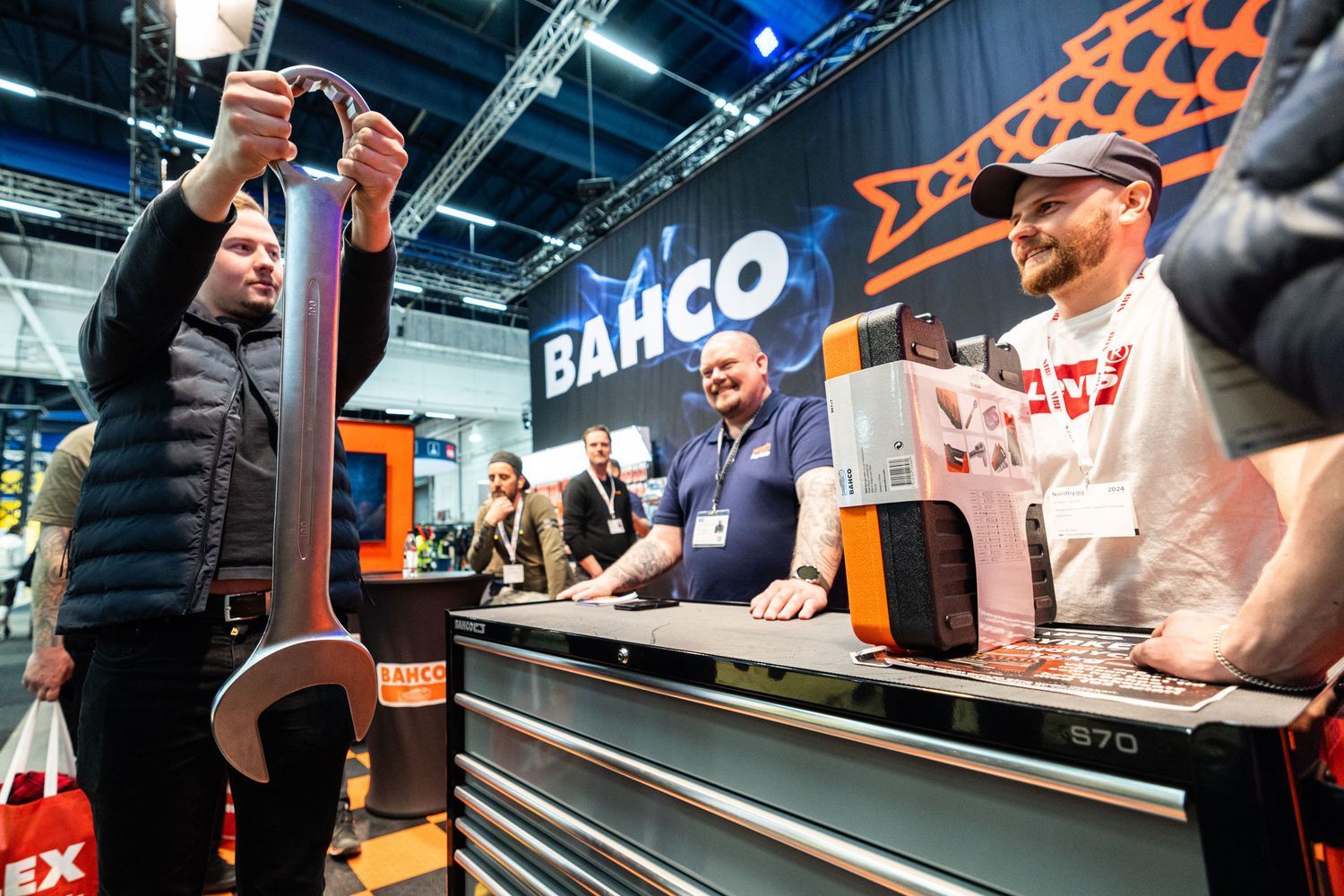 Visitors examine tools at the Bahco brand exhibition stand at a trade show.