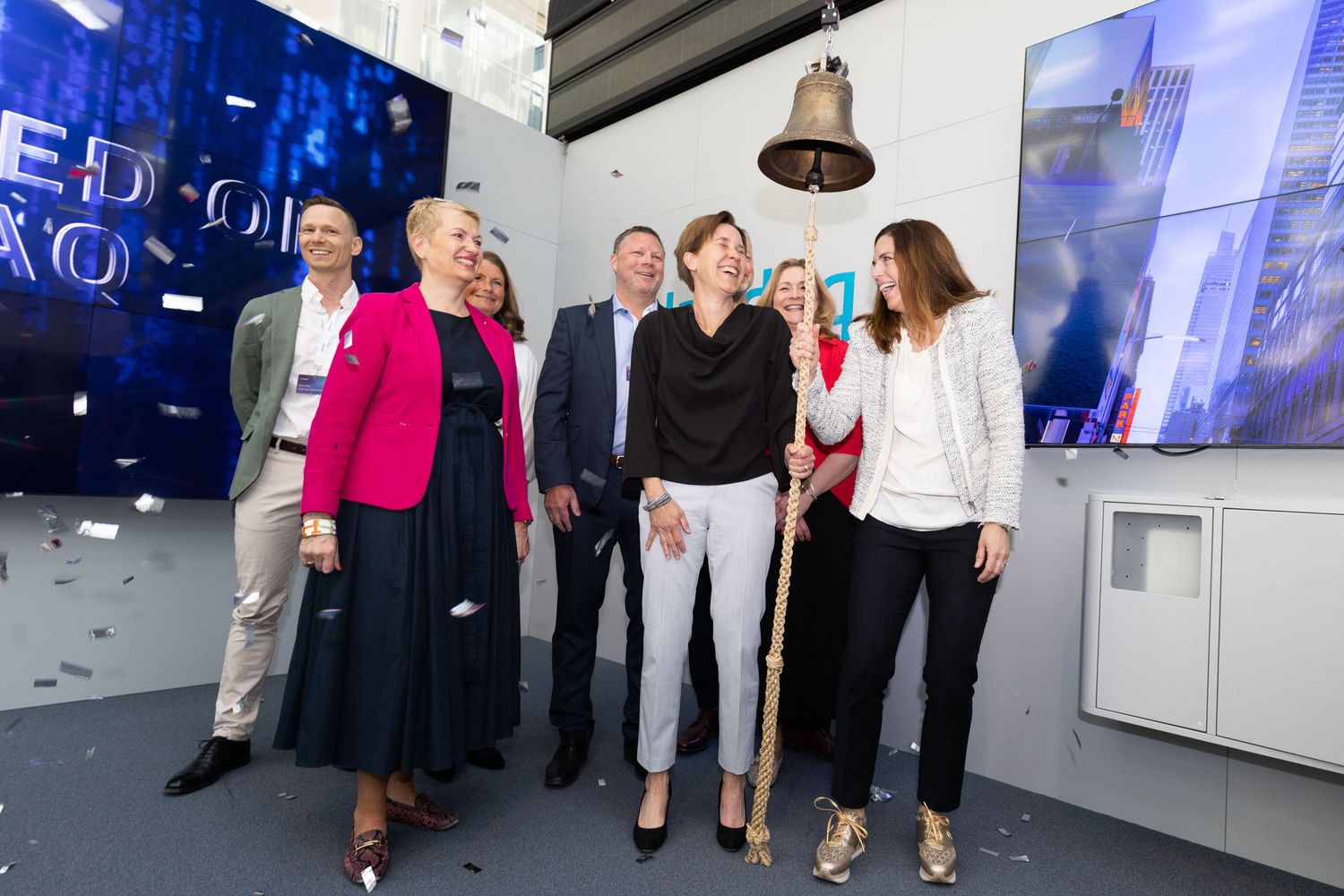 Group of business professionals celebrate a bell-ringing ceremony at a stock exchange listing.