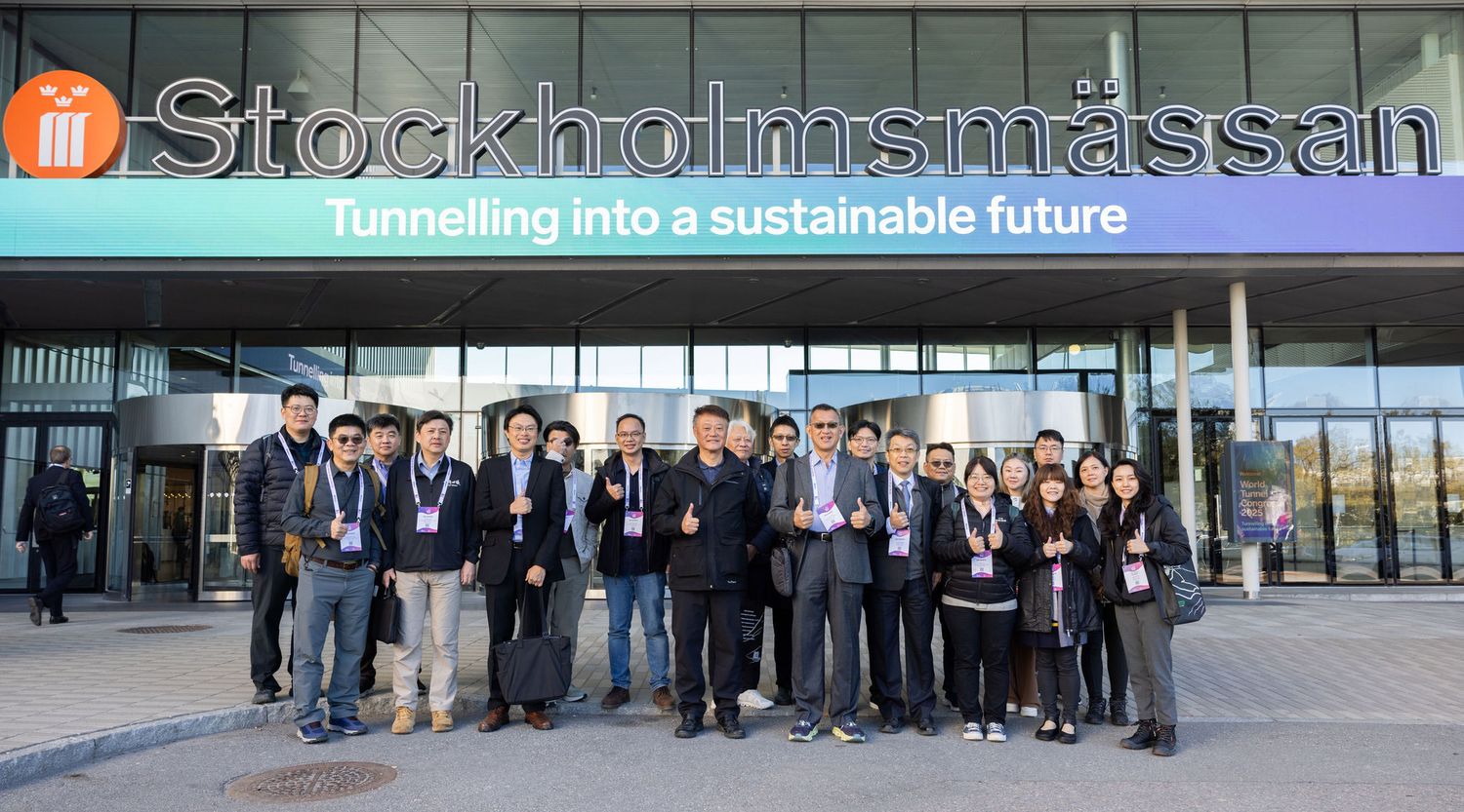 A group of conference delegates poses outside Stockholmsmassan venue at a tunneling sustainability summit.