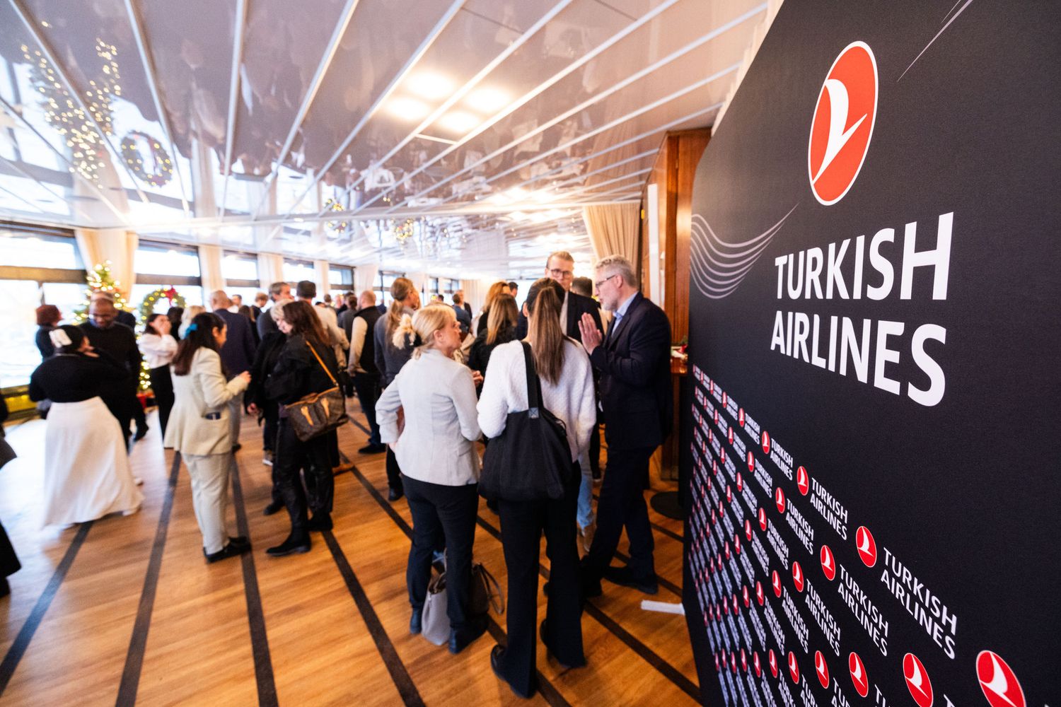 Business professionals networking at a Turkish Airlines sponsored corporate event in an elegant venue.