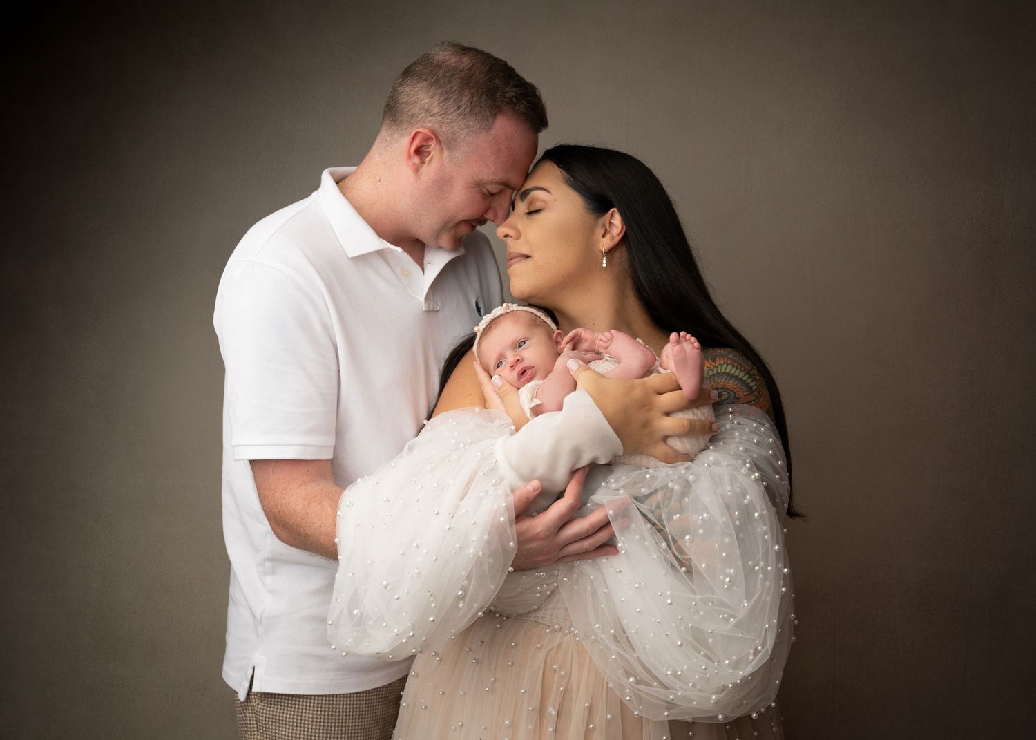 Parents holding their newborn baby during a studio newborn photography session in New Jersey