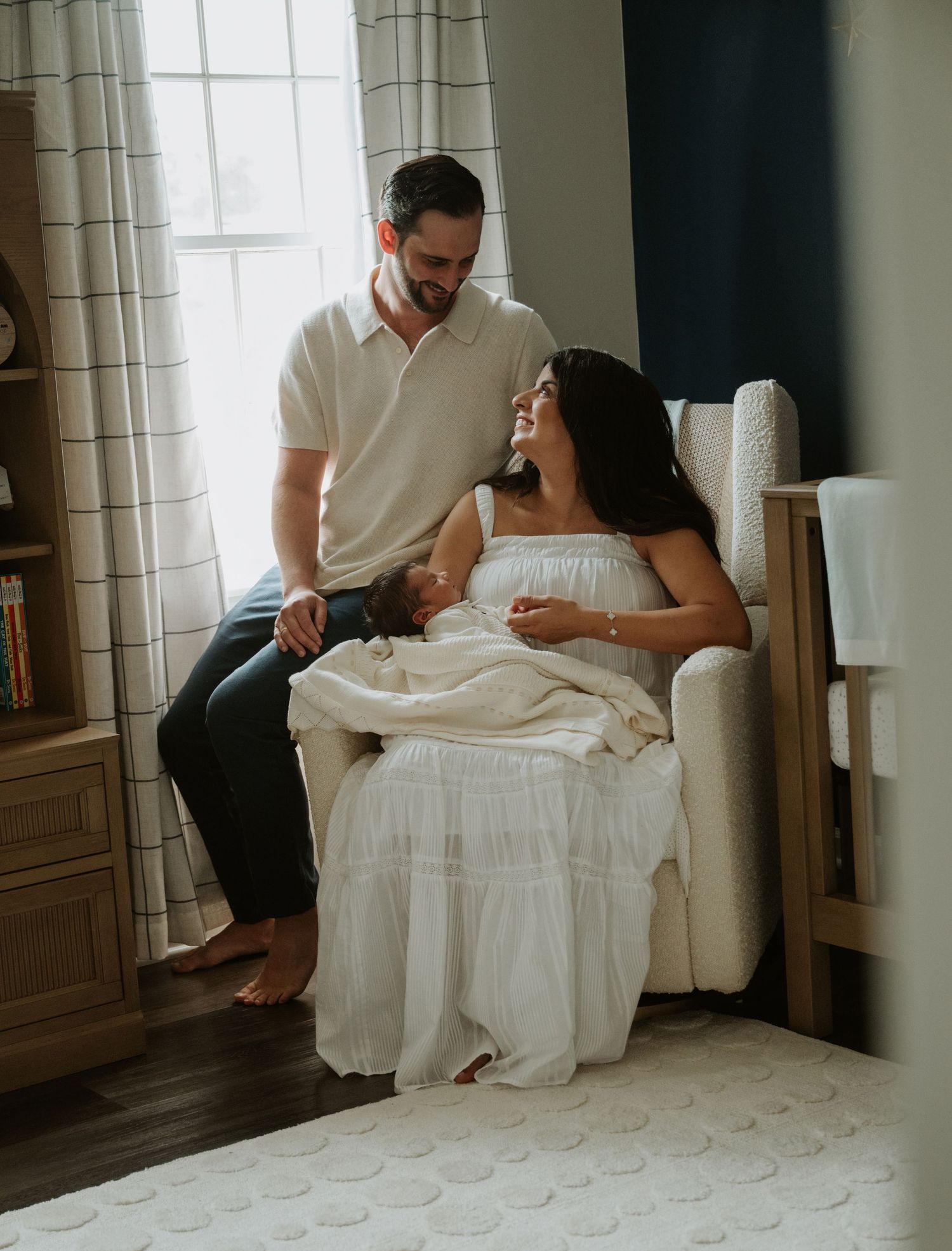Parents relaxing with their newborn baby during an in-home lifestyle newborn photography session in New Jersey.