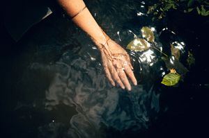 Salt Lake City Utah Water Boudoir Photography by Carl James. Woman in river surrounded by green trees, posing in natural outdoor setting.