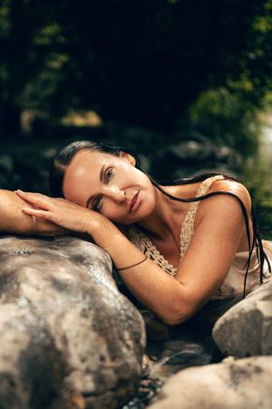 Salt Lake City Utah Water Boudoir Photography by Carl James. Woman in river surrounded by green trees, posing in natural outdoor setting.
