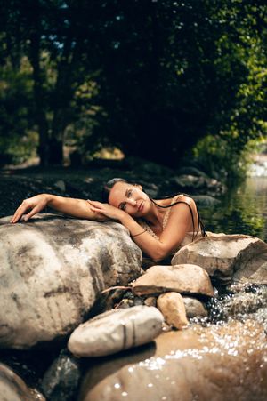 Salt Lake City Utah Water Boudoir Photography by Carl James. Woman in river surrounded by green trees, posing in natural outdoor setting.