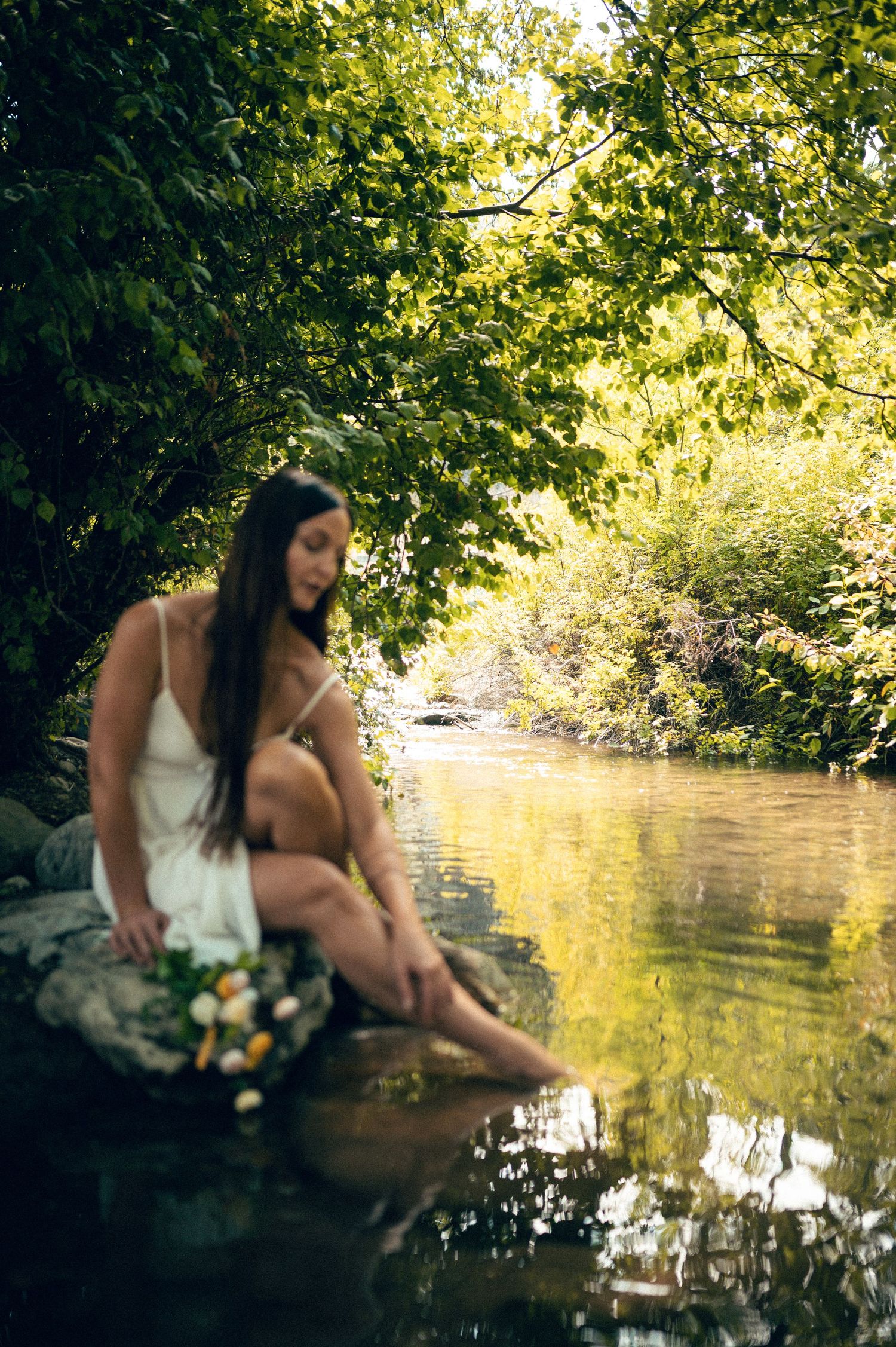 Salt Lake City Utah Water Boudoir Photography by Carl James. Woman in river surrounded by green trees, posing in natural outdoor setting.
