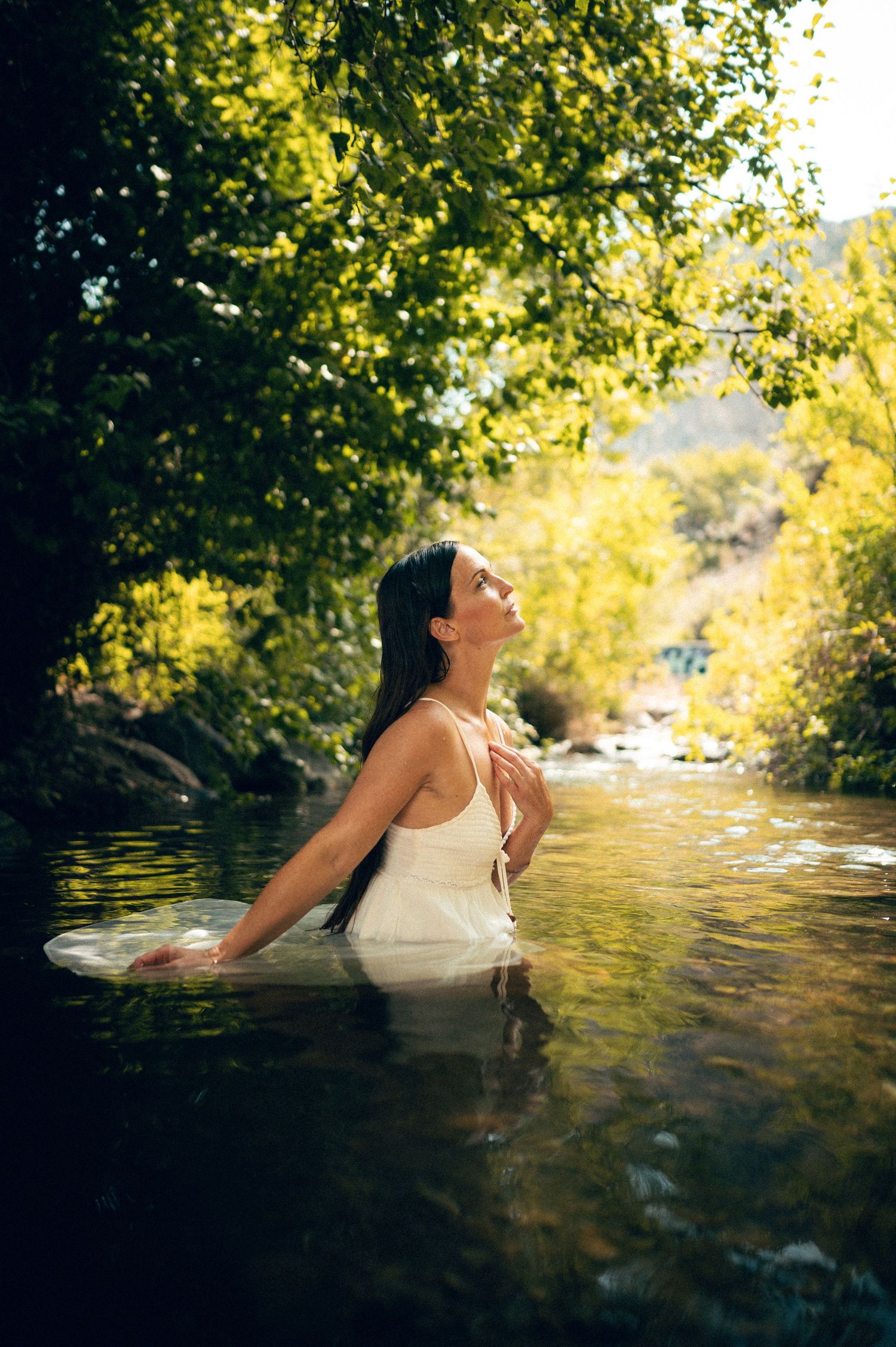 Salt Lake City Utah Water Boudoir Photography by Carl James. Woman in river surrounded by green trees, posing in natural outdoor setting.