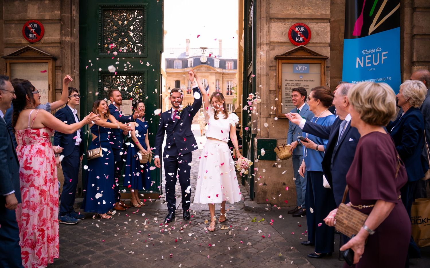 Joyful newlyweds exit venue as guests throw confetti during outdoor wedding celebration in Paris.