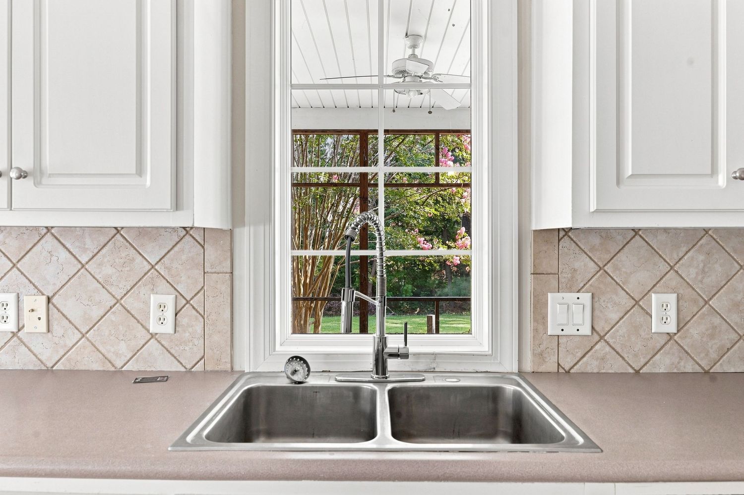 Modern kitchen faucet detail with a clear, perfectly exposed window view using HDR real estate photography in Eastern NC