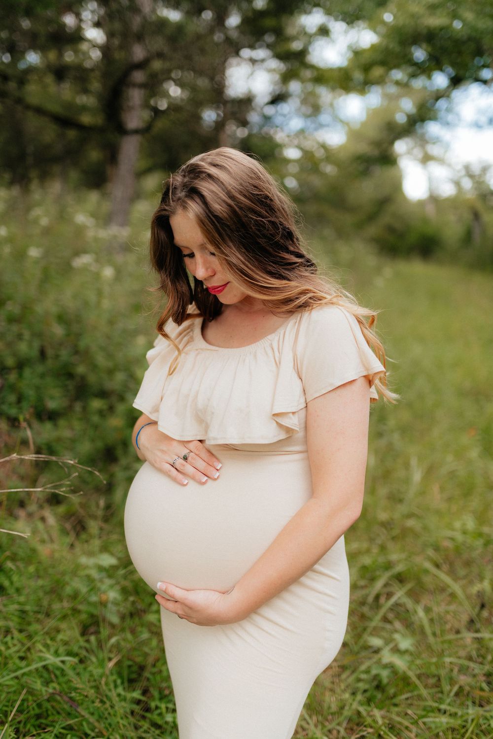 An outdoor maternity photoshoot of an expecting mother holding her baby bump at Berry College in Rome, Georgia by Ella Monroe Photography