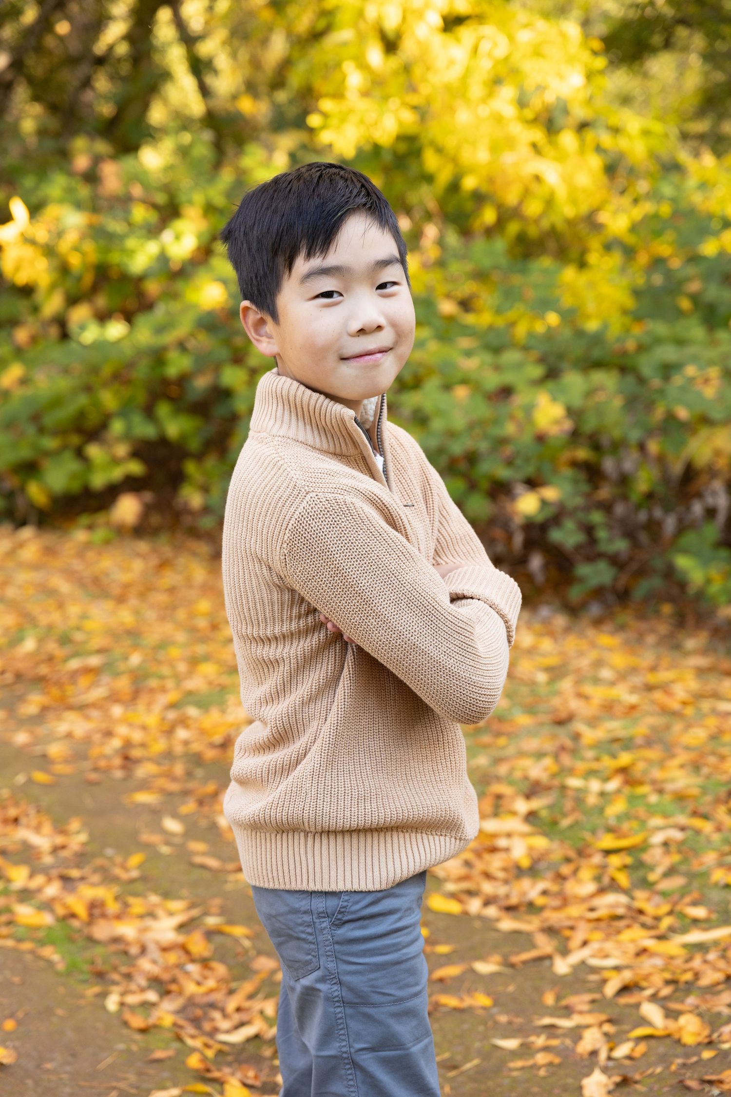 Family of five posing outdoors among vibrant yellow autumn foliage for a fall family portrait photo.