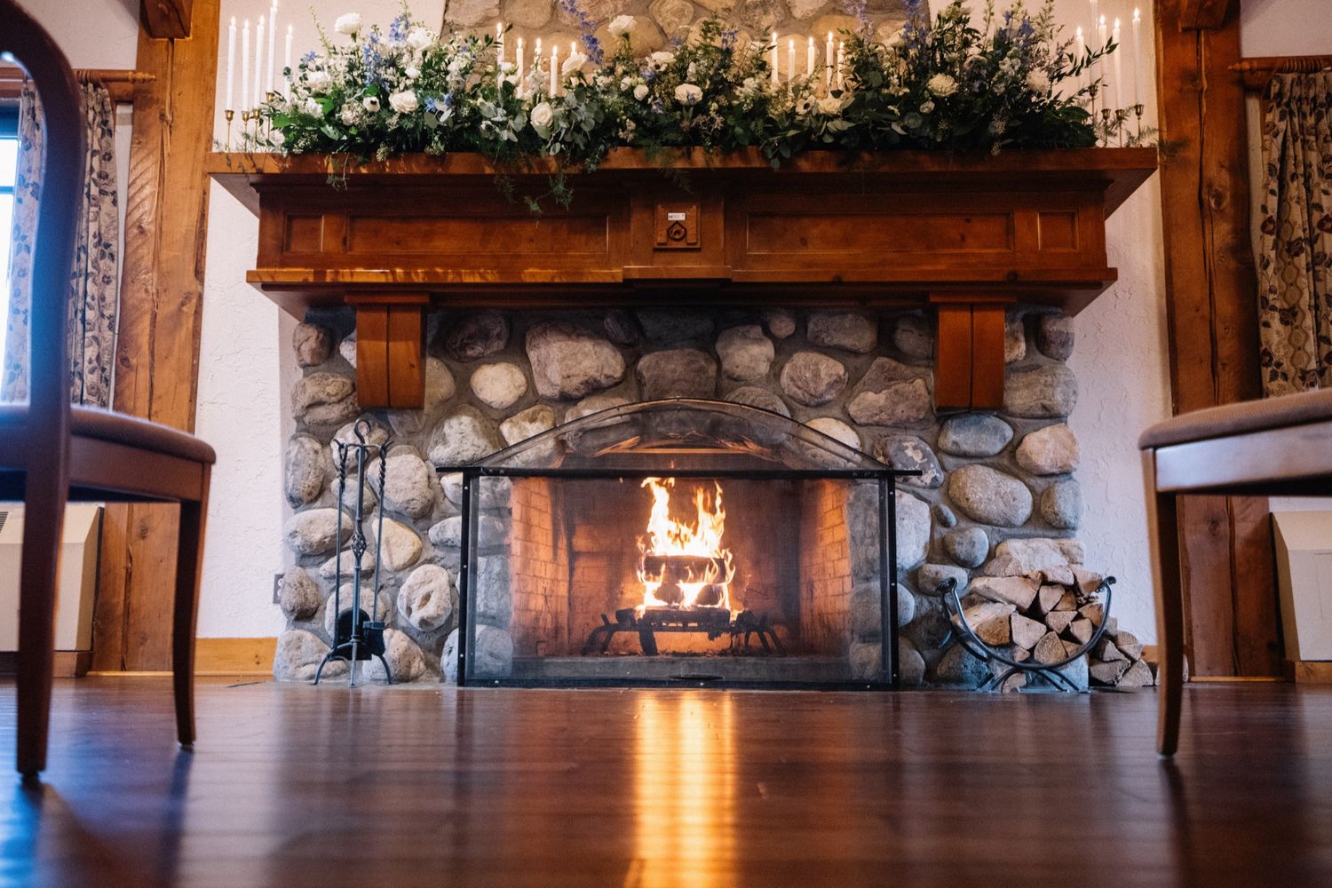 Fleurish greenery and florals on the stone fireplace mantle in the Post Hotel library