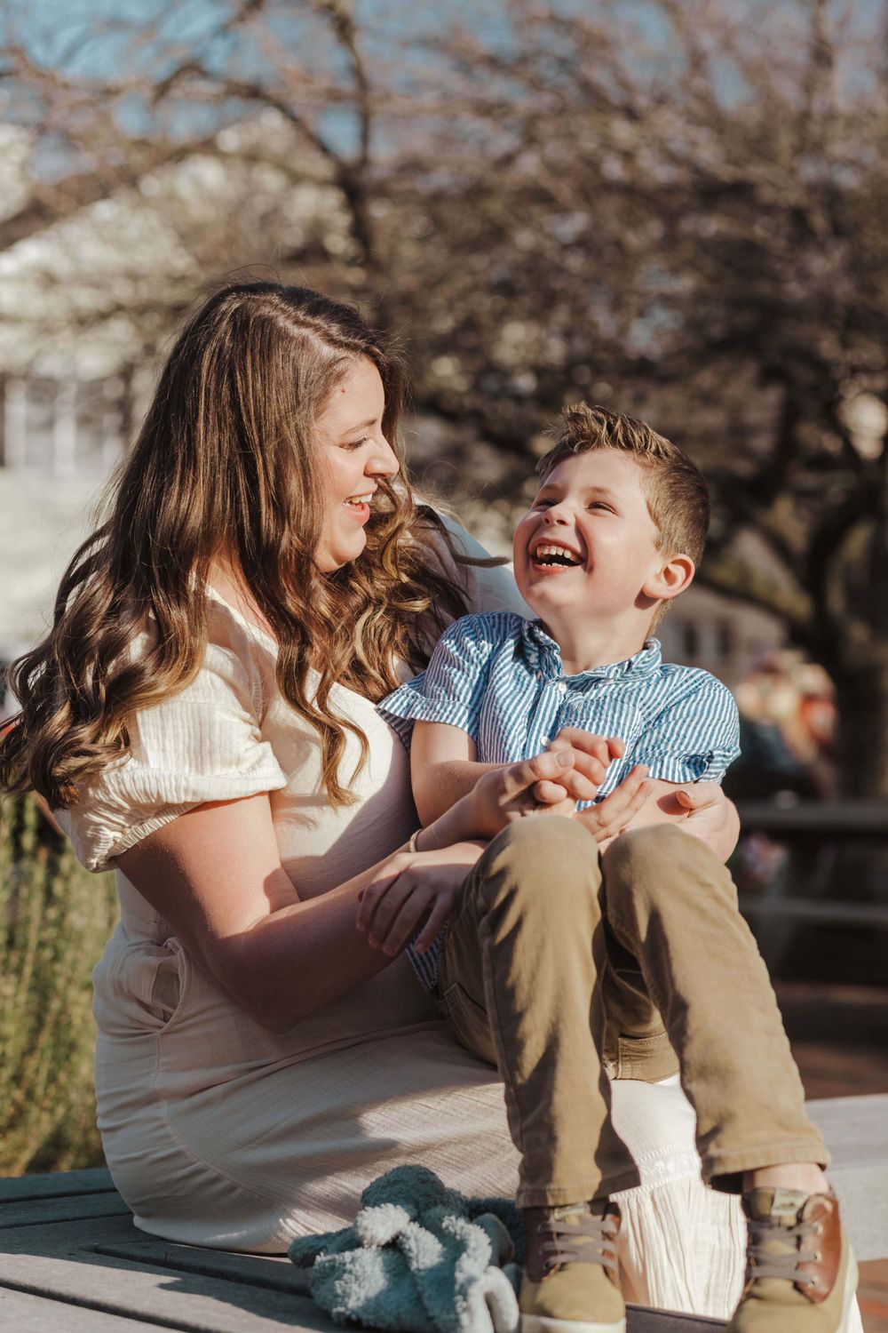 Candid outdoor portrait of two people sharing a joyful moment while sitting together on a sunny day.