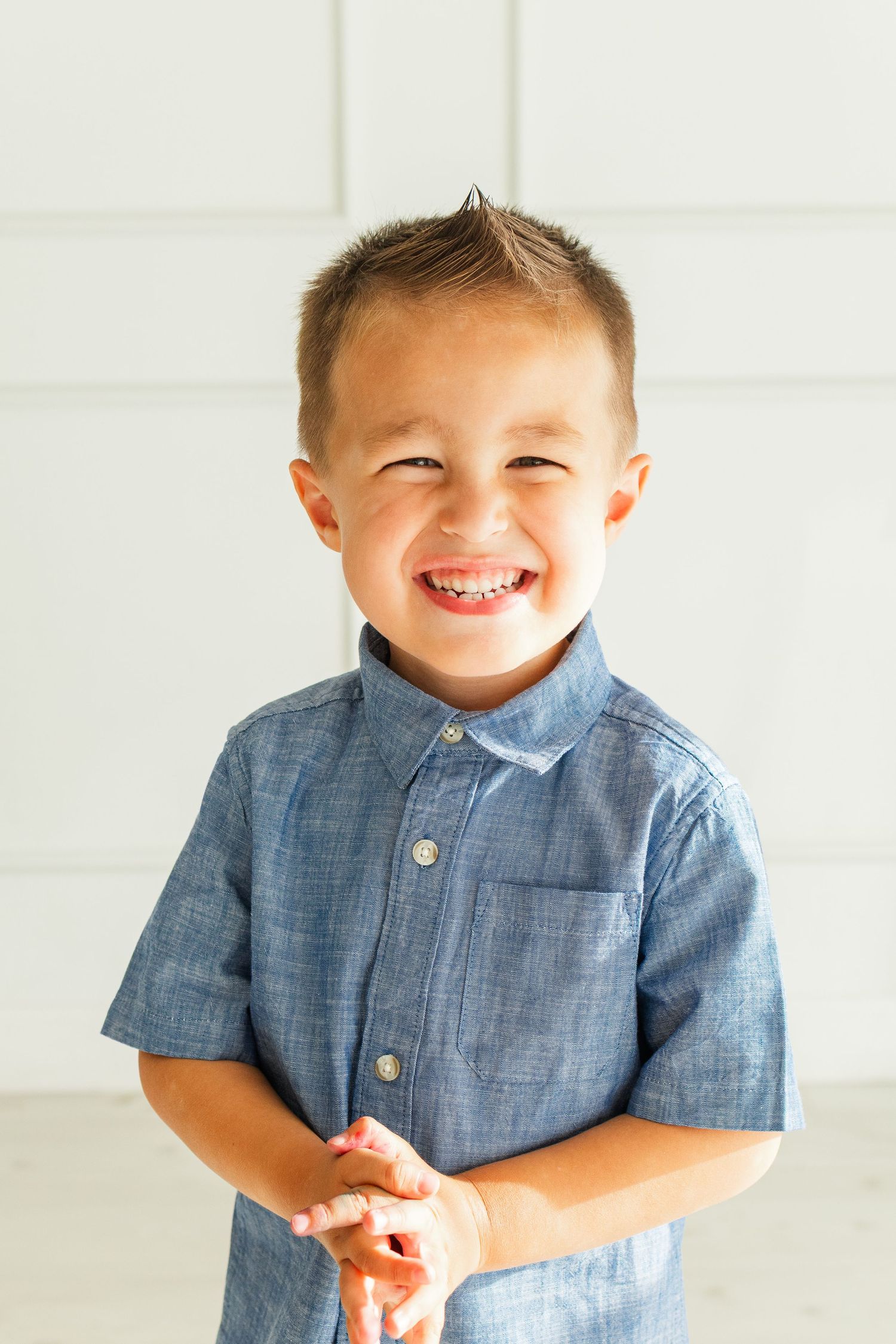 Light and airy studio image of young boy smiling at camera in Mesa, Arizona
