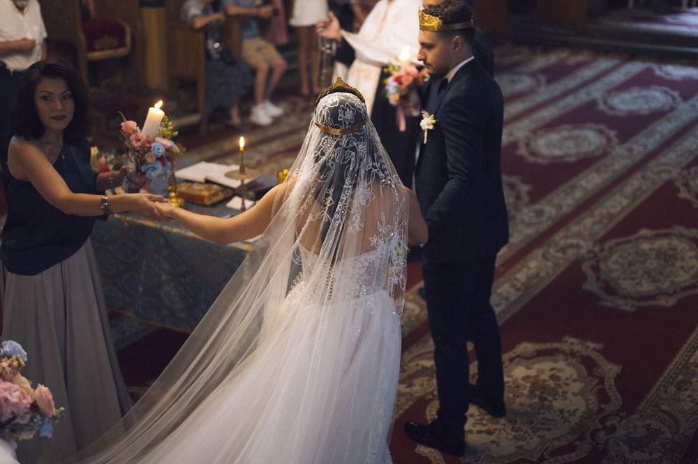 Bride and groom exchanging vows at a church wedding ceremony, bride wearing a lace veil and white gown.