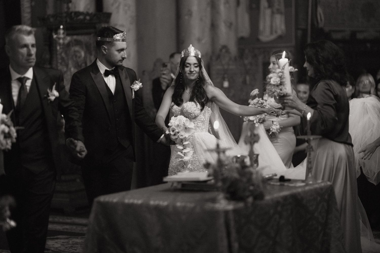 Black and white photo of a bride and groom during a candlelit church wedding ceremony.