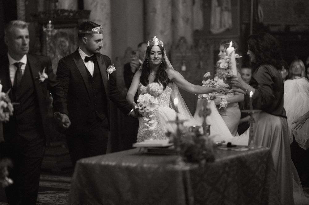 Black and white photo of a bride and groom during a candlelit church wedding ceremony.
