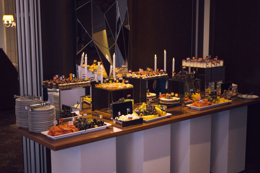 Elegant buffet table with gourmet food displays, candles, and decorative arrangements at an upscale catered event.