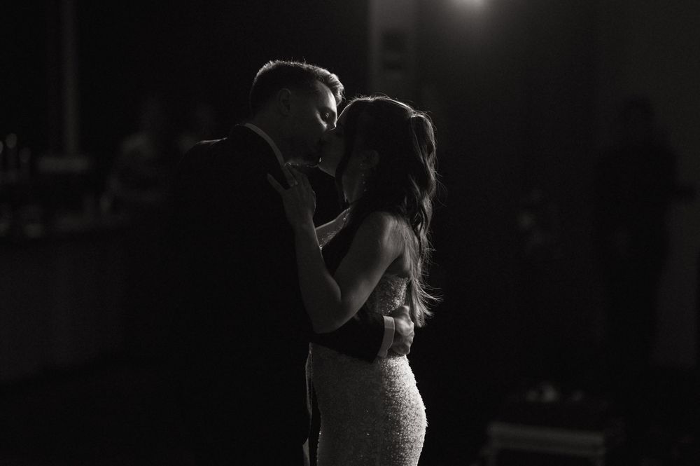 Black and white photo of a couple sharing an intimate first dance moment at their wedding reception.