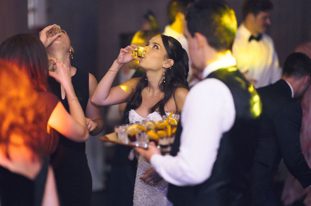 Elegantly dressed guests enjoying appetizers and drinks at a formal evening reception or gala event.