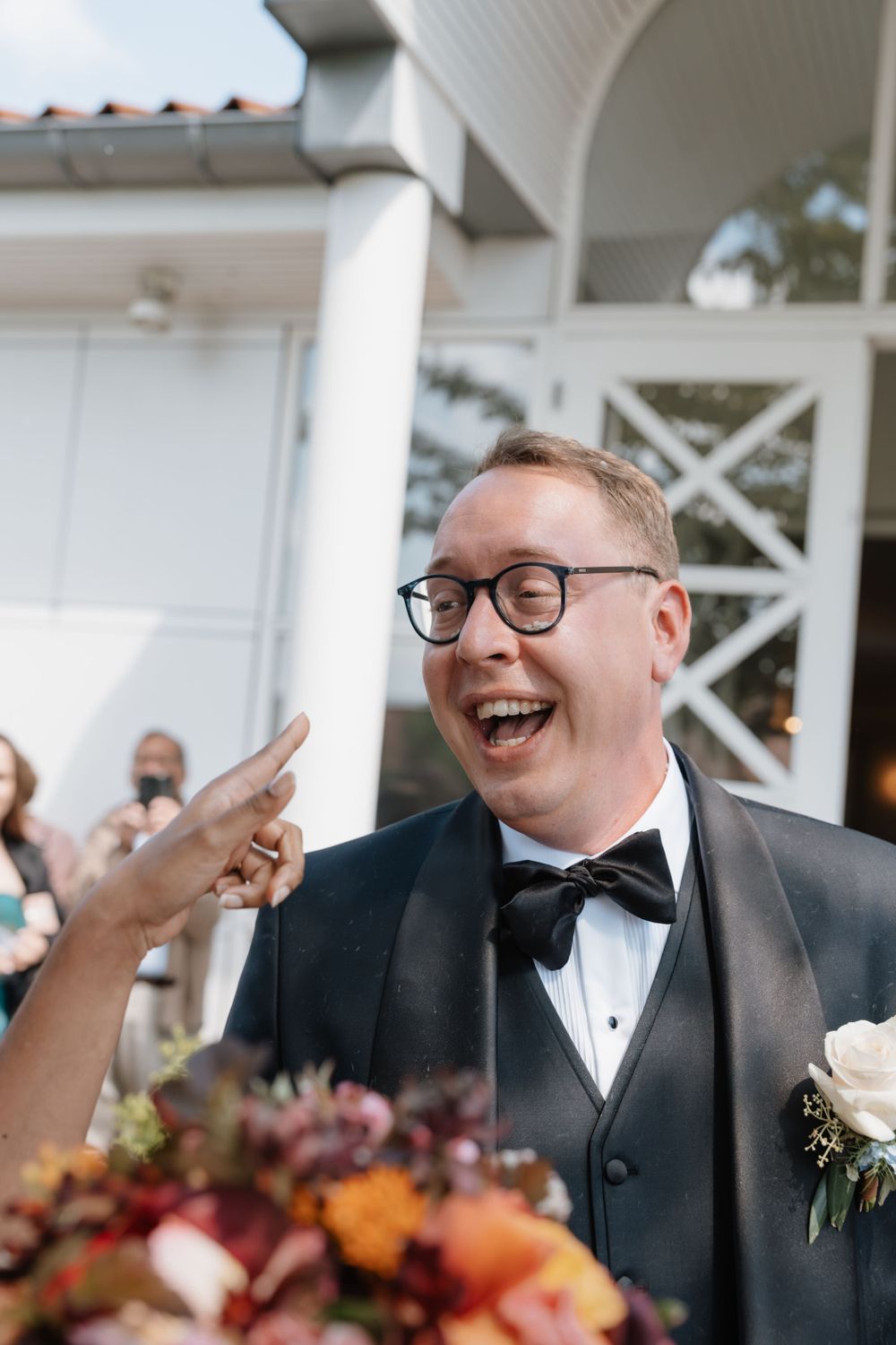 Candid moment of joyful laughter during wedding reception.