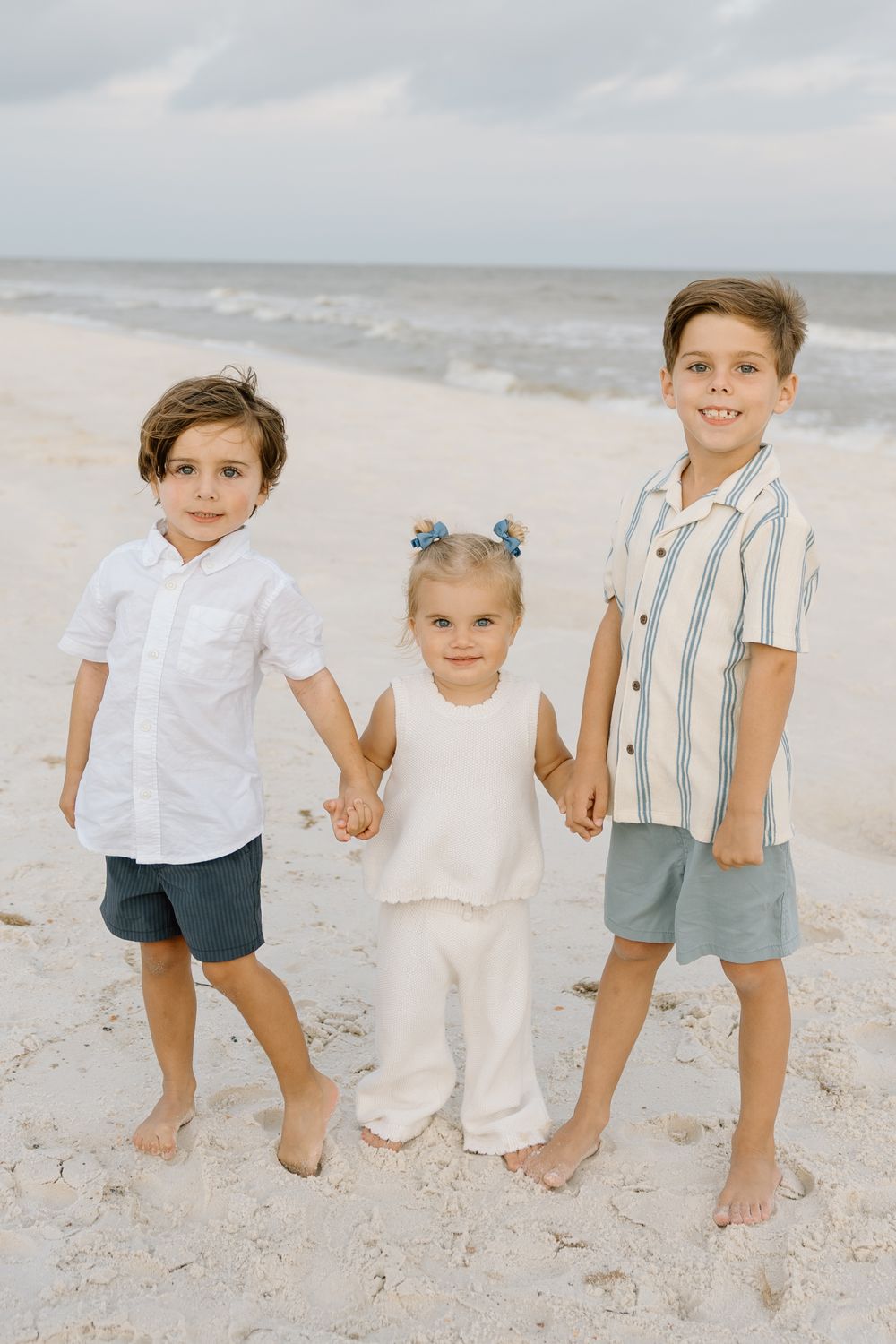 Siblings holding hands on the beach in Gulf shores and Orange beach.