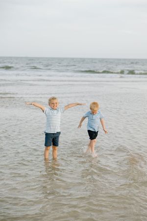 Two siblings playing in the water on the beach in Gulf shores and Orange beach.