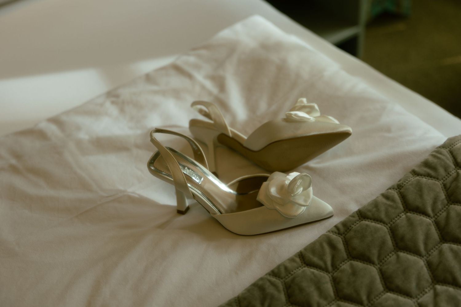 Elegant ivory satin slingback heels with bow detail resting on white hotel bed linens.
Nostalgisch, Vintage, Hochzeit, Bonn