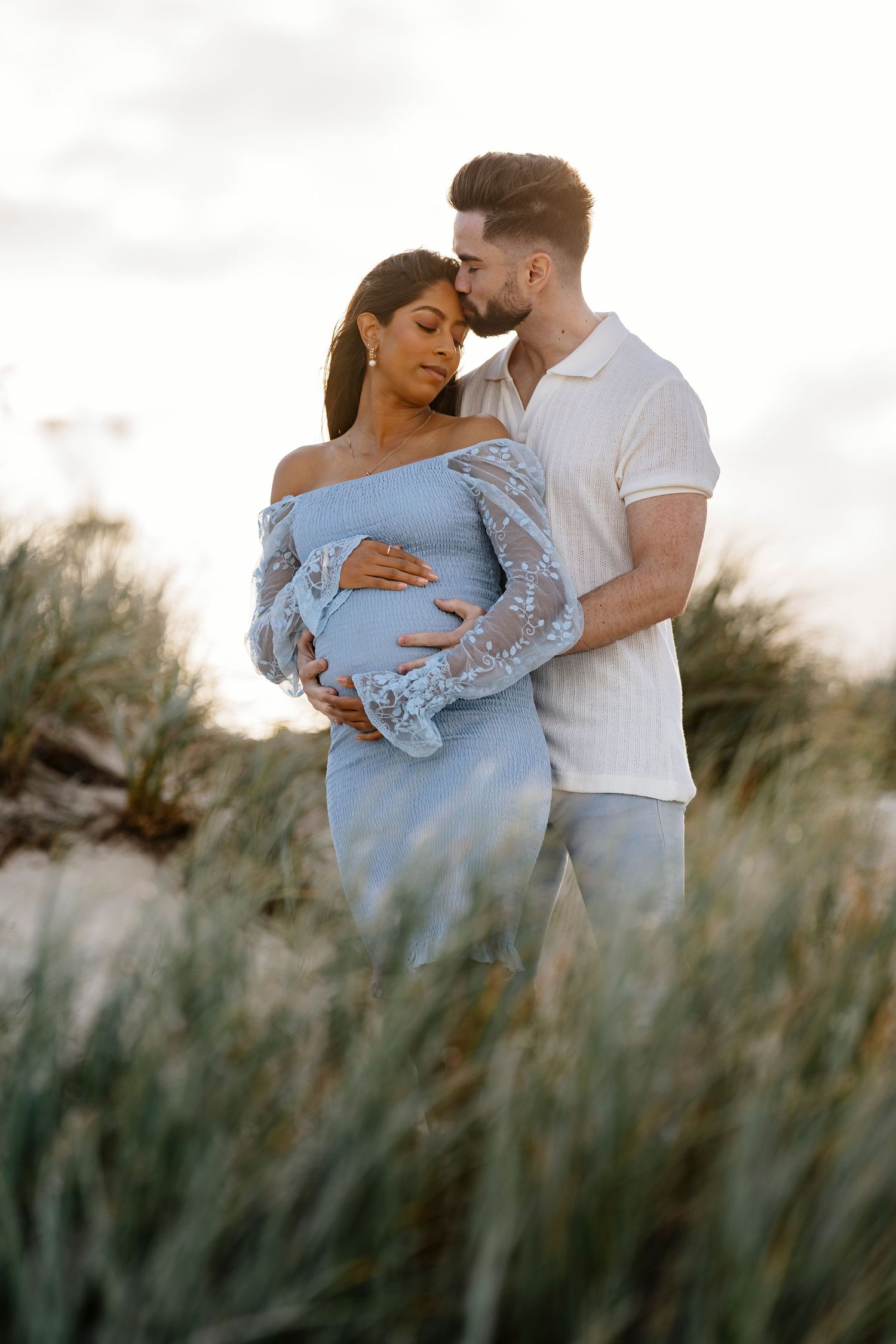 Pregnant mother enjoying a beach maternity photography session with her husband in Brisbane